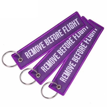 Schlüsselanhänger REMOVE BEFORE FLIGHT violett